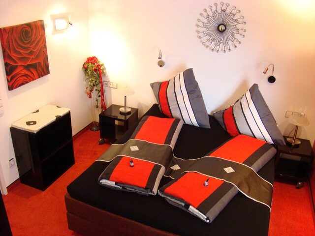 Schlafbereich mit Doppelbett und Rosen-Wandbild