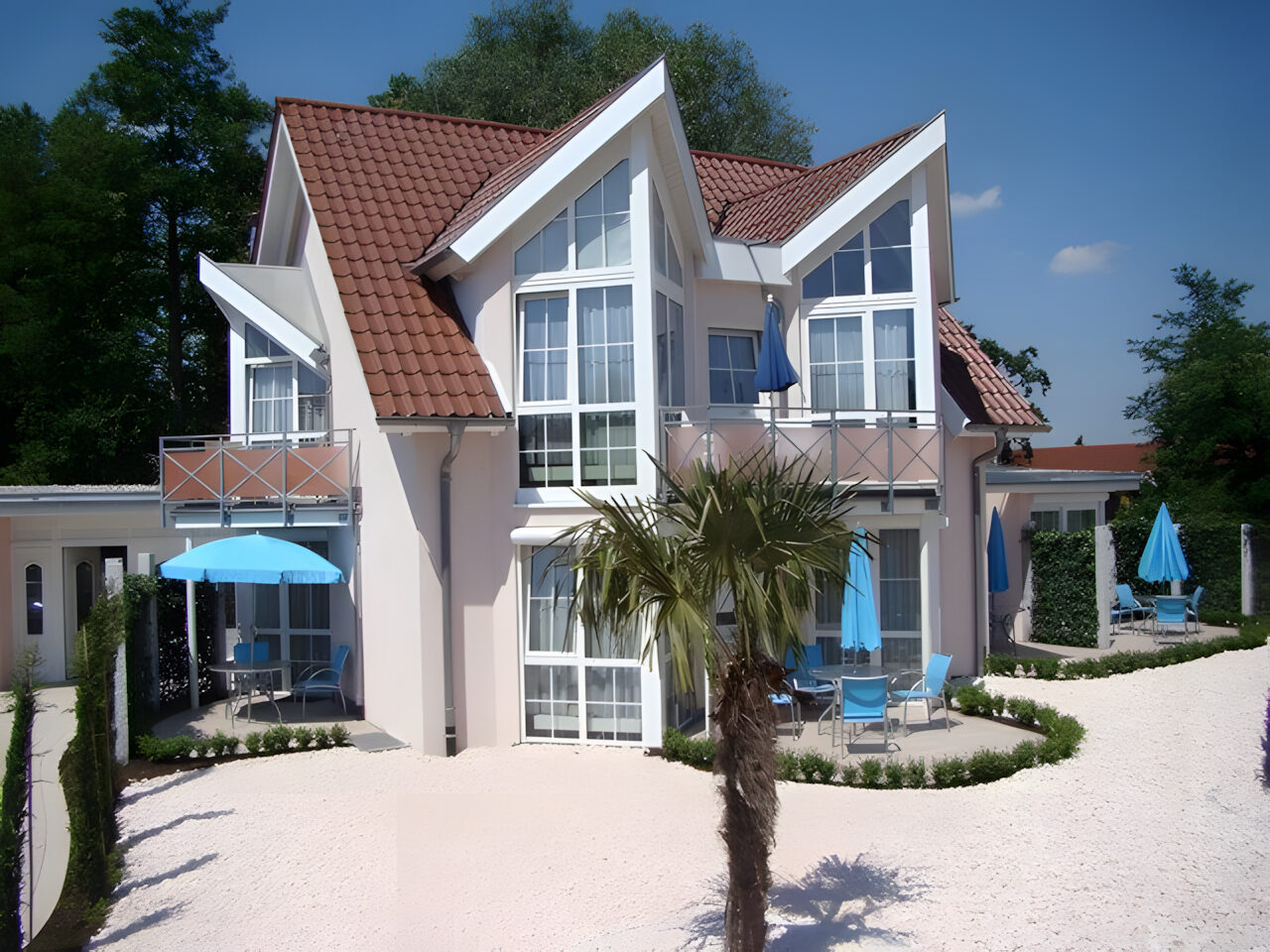 Außenansicht der Bella Casa mit Terrassen und Sonnenschirmen
